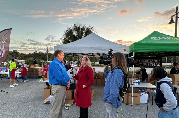 Supervisor Tim Bobanic being interviewed by Meredith McDonough at the Brevard Zoo about the 632 pounds of food collected by the Supervisor of Elections Office for the Share Your Christmas Food Drive.